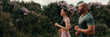 © Andrii Nekrasov - Side view of jogging multiethnic woman and man enjoy their outdoors workout in summer. Team sports. Couple goals and motivation. Happy fit people are cheerfully doing sports. Panoramic. Panoramic