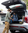 © Raymond Forbes LLC/Stocksy - Road Trip man put luggage in trunk of car