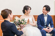 © buritora - 結婚式場のブライズルーム・控室で花束・ブーケを持つ新郎新婦の男女(ドレス試着・衣装合わせ)