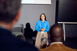 © Boris Jovanovic/Stocksy - Woman speaks at a forum