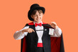 © Pixel-Shot - Little magician with levitating playing card on orange background