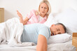 © Pixel-Shot - Snoring mature man with his irritated wife in bedroom