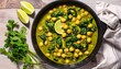 © nizar - Savor a delicious spinach and chickpea curry in a cast iron pan, surrounded by fresh lime wedges and herbs. Perfect for a healthy meal or recipe inspiration.