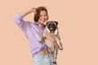 © Pixel-Shot - Young woman with cute pug dog on beige background
