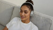 © Aliaksandr - Woman with headphones on a sofa. Beautiful music.