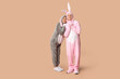 © Pixel-Shot - Beautiful young couple in bunny costume on brown background. Easter celebration