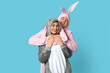 © Pixel-Shot - Beautiful young couple in bunny costume on blue background. Easter celebration