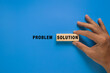 © Dadan - male hand put problem and solution words. isolated on blue background. concept of problem solving