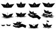 © Matheus - Set of black paper boats and hands holding paper boats