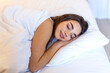 © Graphicroyalty - Beautiful woman sleeping peacefully in bed on white pillow. Good night sleep and wellness concept. Serene brunette female resting under duvet in bright cozy bedroom or luxury hotel apartment.