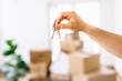 © Westend61 - Hand holding keys with moving boxes indoors in new apartment