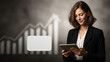 © pattozher - Businesswoman and Growth Chart: A sharp businesswoman, engrossed in her tablet, stands before an ascending growth chart, symbolizing progress, financial gains, and business acumen.