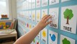 © Alena Yakusheva - A hand touches a visual schedule with icons on a wall, classroom routine, educational organization.