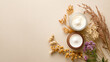 © Liliya - Jar of cream with flowers on beige background, top view. Beauty treatment