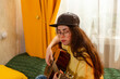 © _KUBE_ - Portrait of Caucasian young female student plays guitar while sitting on her bed at home. Music education concept. Creative learning and artistic expression.