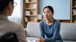 © Николай Срибяник - Young Asian woman talking to therapist during counseling session.