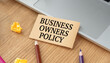 © Pawel - Business Owners Policy (BOP) text on a craft card on a wooden desk with a laptop and pencils.