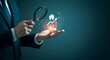 © MJ STUDIO - Businessman holding magnifying glass looking at house investment hologram representing real estate market growth and property value success