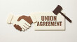 © Chopang.studio - Union agreement concept with paper cut handshake and judge gavel symbolizing legal contract and cooperation in labor relations