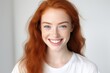 © MartaKlos - Smiling young woman with red hair and freckles in a simple background during daytime Generative AI