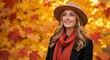 © Vasiliy - Portrait of a happy woman in autumn fashion. Smiling young female wearing a hat and scarf outdoors with colorful fall leaves in the background
