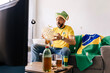 © kleberpicui - Brazilian football fan watching match at home while supporting national team. Emotional sports moment showing excitement, anticipation and entertainment lifestyle during televised competition.