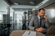 © Migma_Agency - Stressed businessman working on laptop in modern corporate office