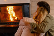 © Maria Vitkovska - Couple embracing by warm fireplace, enjoying cozy intimate moment at home