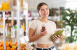 © JackF - Young woman buyer chooses red and green smoothie in bottle in grocery store