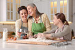 © New Africa - Smiling grandmother, her daughter and granddaughter cooking together at white marble table in kitchen