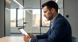 © Rie - Businessman using tablet in modern office.