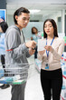 © DC Studio - Male customer and female pharmacist compares medicine with information on prescription slip. The professional employee reviews instructions and recommends appropriate medications and supplements.
