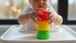 © Enigma - Baby stacking colorful toy cups in high chair, developing motor skills, learning coordination
