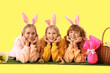 © Pixel-Shot - Young girl with bunny ears celebrating Easter on yellow background