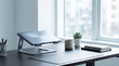 © Robert - Minimalist home office setup with laptop stand, coffee mug, and plant on a wooden desk, bright natural light from window.