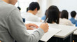 © TYAK_FACTORY - Rear View of University Lecture with Students Taking Notes
