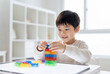 © Meow Creations - Young asian boy playing with colorful building blocks on a light table