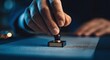 © Sultan - Close-up of a hand stamping a document with a seal.