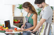 © auremar - portrait of a cheerful young couple cooking salad together