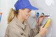 © auremar - real woman electrician fixing socket electricity problem