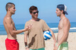 © auremar - three young men at the beach holding a ball