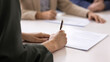 © fizkes - Close up image of woman signing contract during formal meeting in boardroom, buying company services, take loan or mortgage. Commitment of business parties concluding official deal at conference table