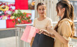 © Art_Photo - Two young asian women friends looking inside pink shopping bag in mall, Excited female shoppers checking new purchased items, Consumerism, summer sale discount, retail therapy and lifestyle concept