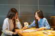 © Art_Photo - Young asian female food bloggers looking at menu to review restaurant, Happy foodie influencers choosing meal for social media content, Lifestyle, dining recommendation and vlogger concept