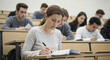© bastet - Young woman studying and taking notes in university classroom