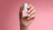 © CreativeArt - Woman hand holding pink nail polish bottle, showing perfect manicure, beauty treatment and self care concept