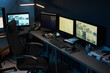 © pressmaster - Empty modern office workspace featuring multiple computer monitors displaying surveillance footage, keyboard, mouse, telephone, coffee cup, and office supplies on desk