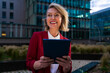 © Westend61 - Businesswoman using tablet in urban setting during evening