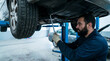 © Iqbal - Mechanic working on car in auto repair shop