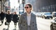 © mashimara - City Style & Confidence: A stylish individual walks confidently down a bustling urban street. Sunlight enhancing her modern outfit, showcasing poised poise and self-assured demeanor.